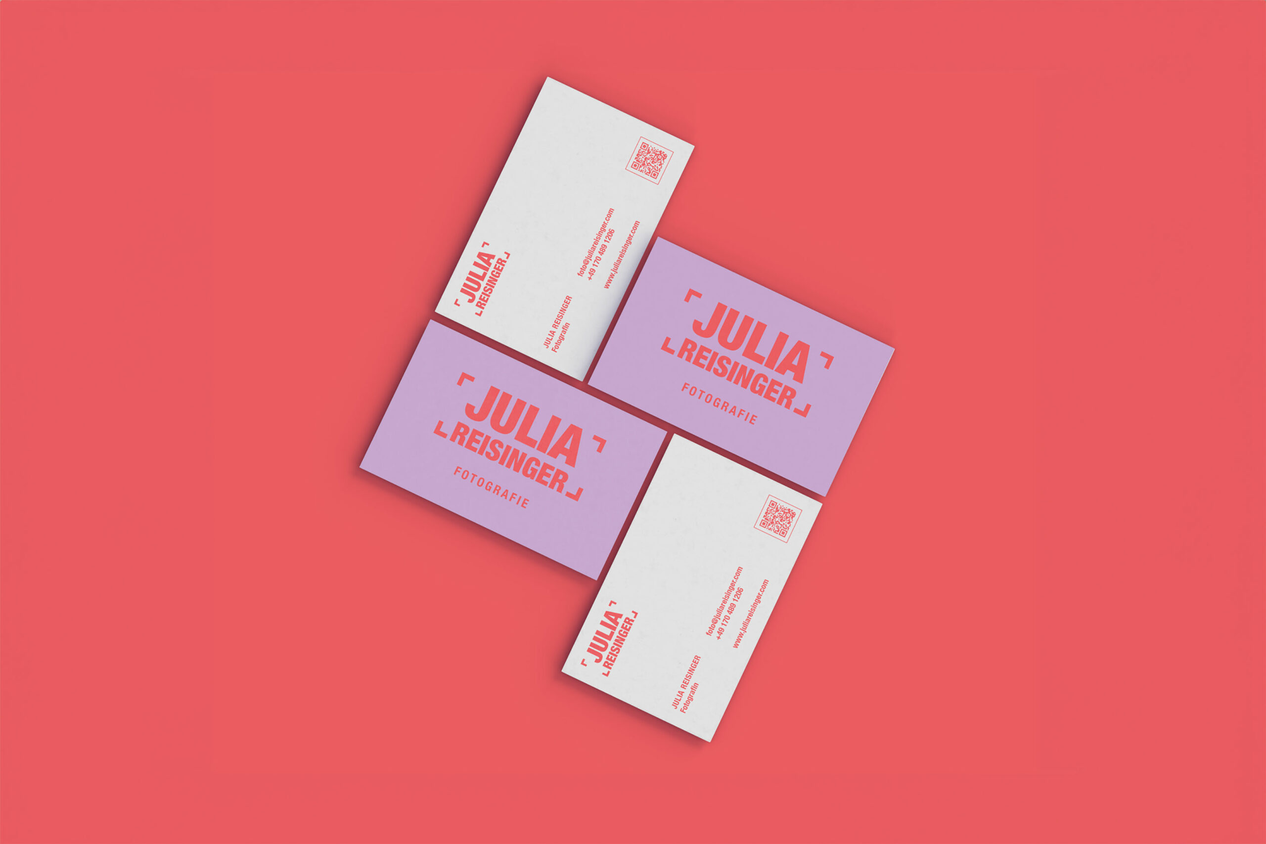 Visitenkarten-Design für die Fotografin Julia Reisinger. Die Karten präsentieren ein auffälliges Branding mit kräftigen Farben in Rot und Lila. Der Name und das Logo sind groß und zentral platziert, mit dem Zusatz 'Fotografie' darunter. Eine saubere, minimalistische Gestaltung sorgt für eine moderne und professionelle Wirkung. Die Rückseite der Visitenkarten enthält Kontaktinformationen und einen QR-Code. Das Design unterstreicht die kreative und zeitgemäße Identität der Fotografin.